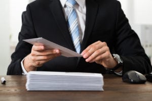 man in suit holding evelopes