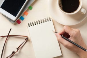 notebook and cell phone with coffee cup